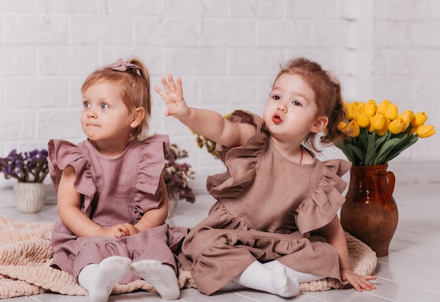 Duas meninas em lindos vestidos no estúdio com flores