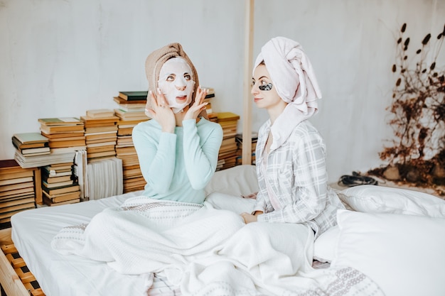 Duas meninas fazem máscaras e adesivos para a beleza do rosto e do cabelo