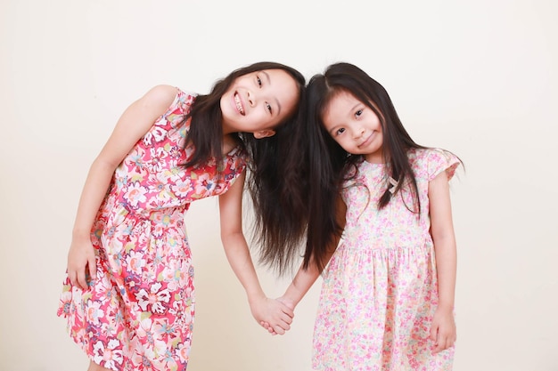 Duas meninas felizes de alegria em comprimento total isoladas no fundo branco