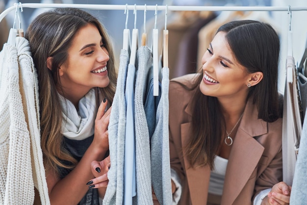 Duas meninas felizes na loja de roupas durante as compras. Foto de alta qualidade