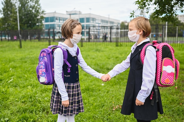 Foto duas meninas no primeiro dia de aula com máscaras protetoras