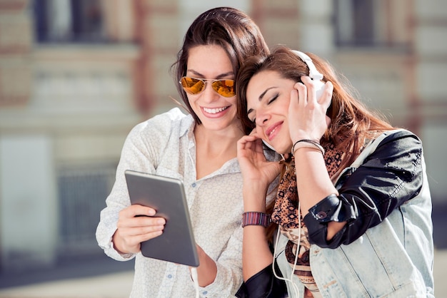 Duas meninas ouvindo música na cidade se divertindo