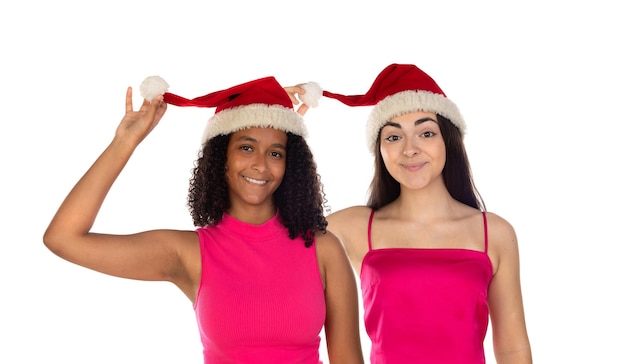 Duas meninas sorridentes felizes em chapéus de natal, olhando para a câmera