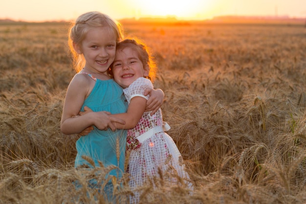 Duas meninas sorridentes no campo de trigo
