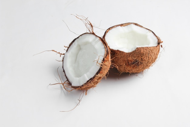 Duas metades de coco picado em um fundo branco