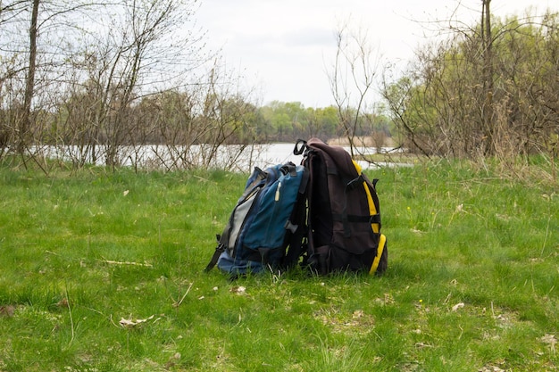 Duas mochilas turísticas no conceito de caminhada na margem do rio