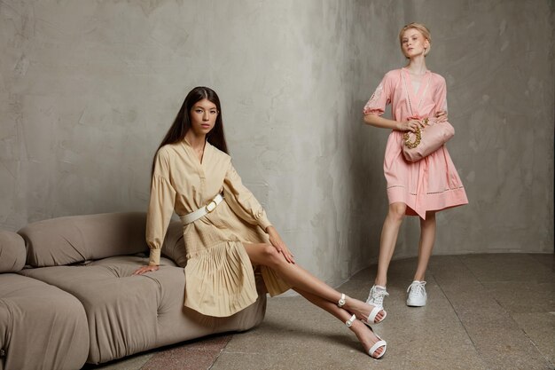Duas modelos de moda em vestidos de verão vestidos bege e rosa pêssego com mangas