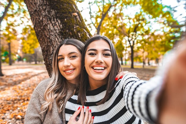 Duas mulheres a tirar uma selfie num parque.