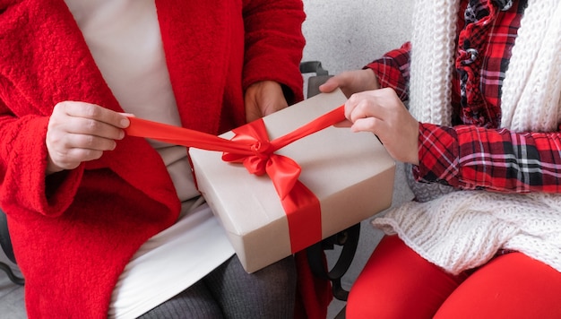 Duas mulheres abrindo presentes na véspera de feriados de Natal e Ano Novo.