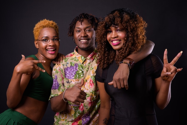 Foto duas mulheres africanas e um homem africano juntos no preto