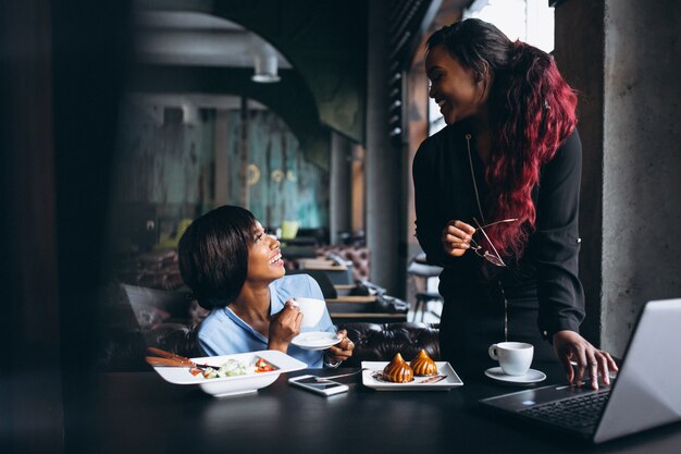 Duas mulheres afro-americanas com laptop e almoço