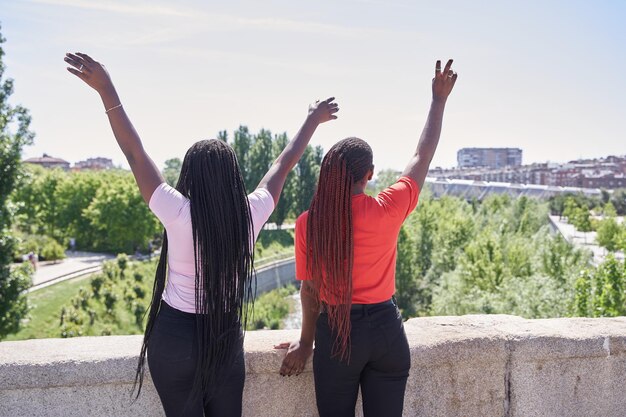 Duas mulheres afro-americanas irreconhecíveis com longas tranças