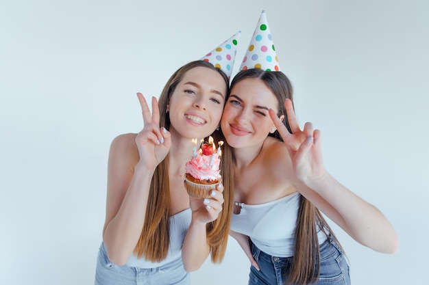 Duas mulheres amigos roupas europeias chapéus de aniversário posando. Conceito de estilo de vida de pessoas.