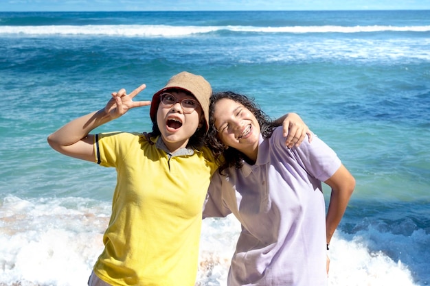 Duas mulheres asiáticas com uma expressão excitada viajando na praia