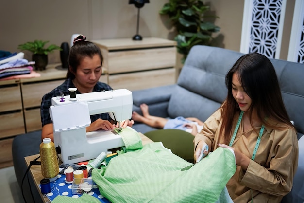 Duas mulheres asiáticas costurando e vendendo roupas online ideia de negócio online