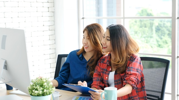 Duas mulheres asiáticas jovens trabalhando com computador em casa escritório com emoção feliz, trabalhando em casa, empresa de pequeno porte, conceito de estilo de vida casual de escritório