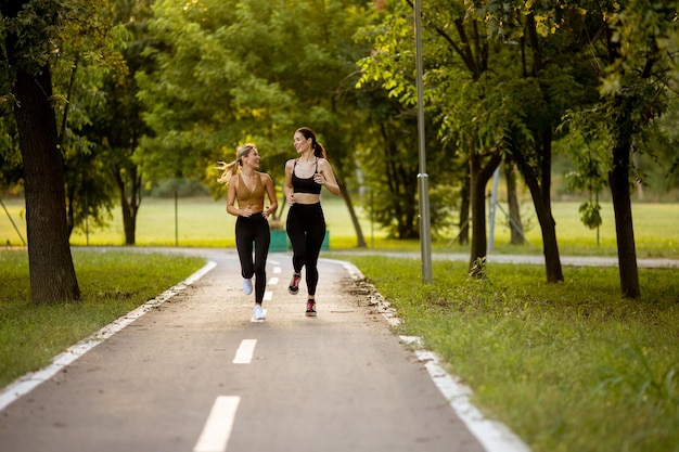 Duas mulheres bonitas correndo em uma pista no parque