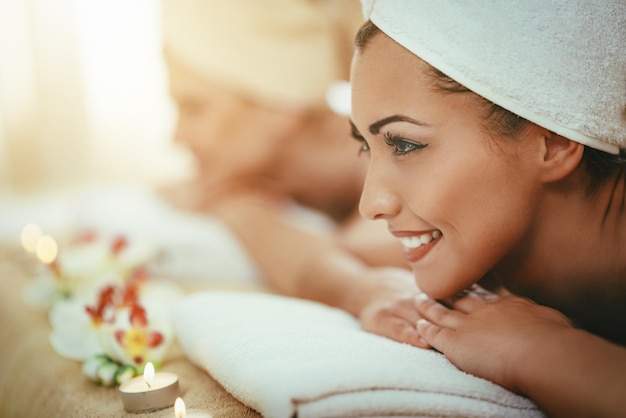 Foto duas mulheres bonitas estão desfrutando durante um tratamento de cuidados com a pele em um spa.