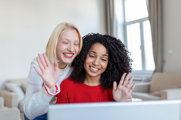 Duas mulheres bonitas usando laptop para uma chamada de vídeo online e brindando online com seus amigos Festa online para amigos