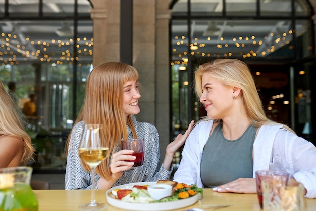 Duas mulheres brancas e positivas gostam de passar tempo juntas em restaurante