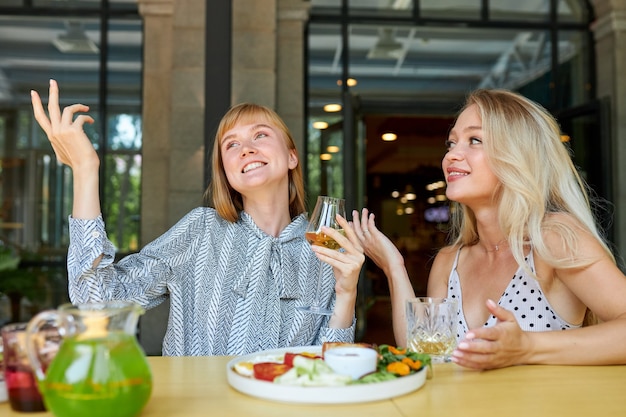 Duas mulheres brancas e positivas gostam de passar tempo juntas em um restaurante