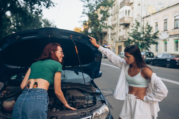 Duas mulheres com carro quebrado na estrada Abra a capa