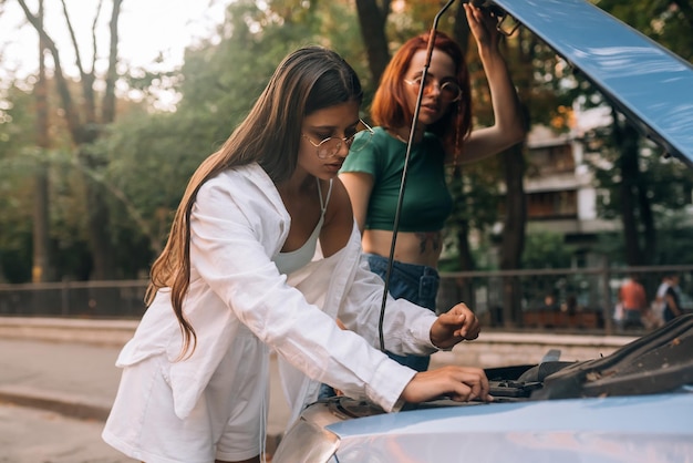 Duas mulheres com carro quebrado na estrada Abra a capa