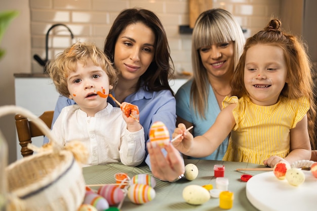 Duas mulheres com seus filhos se preparando para a celebração da Páscoa