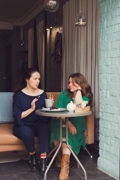 Duas mulheres conversando e tomando café em um café