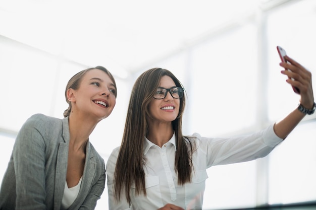 Duas mulheres de negócios atraentes tiram selfies