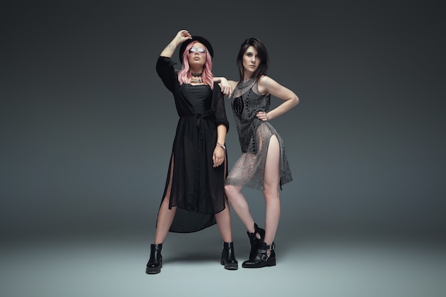 Duas mulheres elegantes vestindo roupas da moda pretas posando