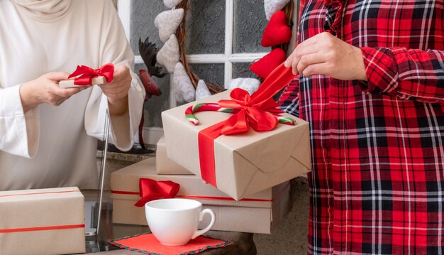 Duas mulheres embalando presentes na véspera dos feriados de Natal e Ano Novo.