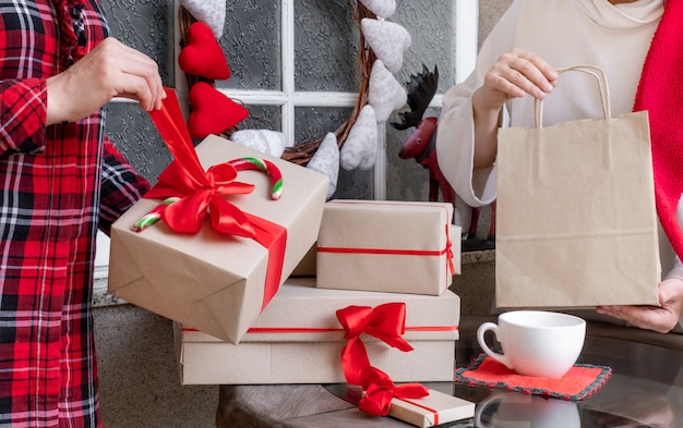 Duas mulheres embalando presentes na véspera dos feriados de Natal e Ano Novo.