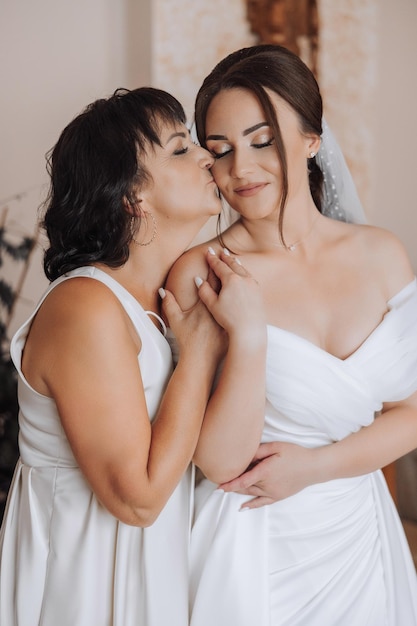 Foto duas mulheres estão se abraçando. uma delas está vestindo um vestido de noiva.