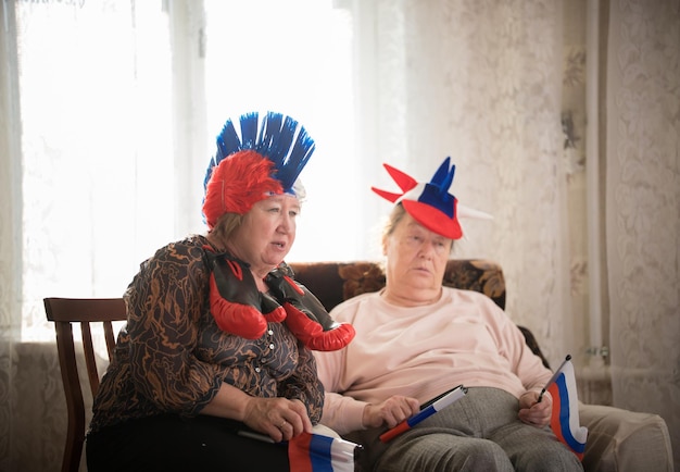 Duas mulheres idosas assistindo tv em acessórios russos