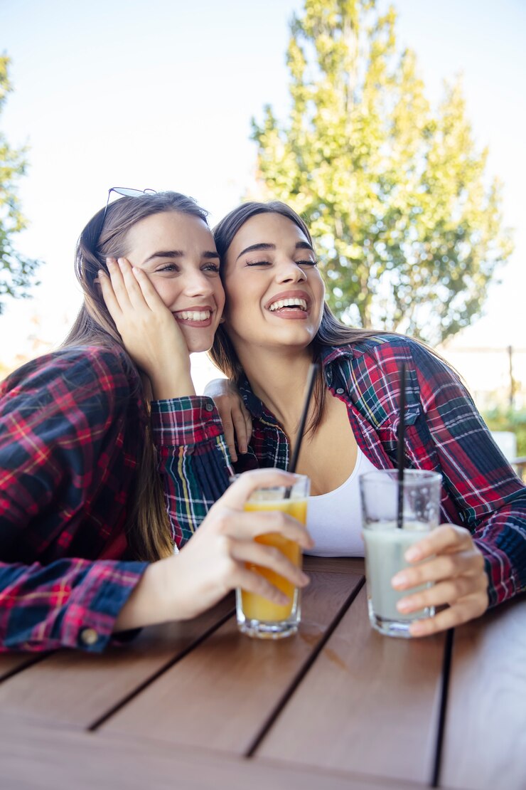 Foto duas mulheres jovens bebendo suco e limonada no parque