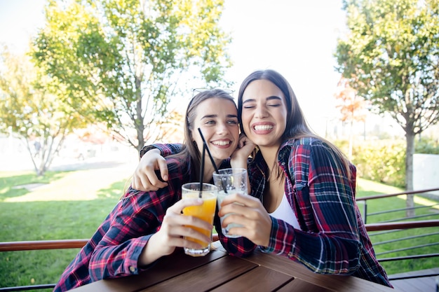 Duas mulheres jovens bebendo suco e limonada no parque