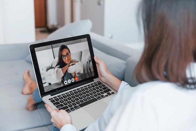 Duas mulheres jovens conversam online usando tablet