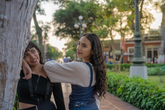 Duas mulheres jovens de beleza posando juntas em um parque