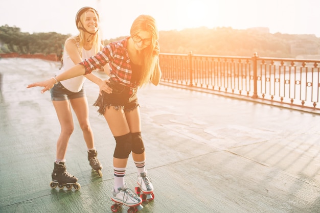 Duas mulheres jovens magras e sexy com patins