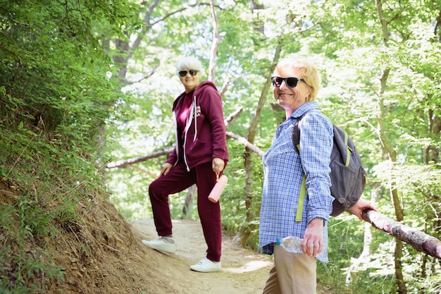 Duas mulheres maduras passando férias ao ar livre caminhando na floresta