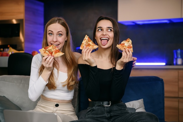 Duas mulheres se divertindo em casa, abrindo a caixa de pizza, entrega de comida, festa em casa