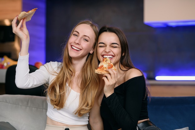 Duas mulheres se divertindo em casa, abrindo a caixa de pizza, entrega de comida, festa em casa