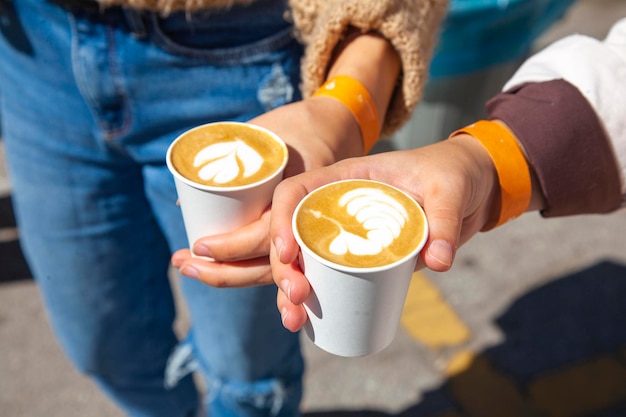 duas mulheres segurando uma xícara de café com latte art