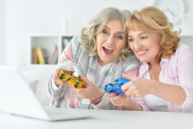 Duas mulheres sênior jogando jogo de computador no laptop