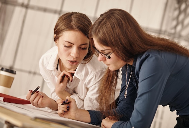 Duas mulheres trabalhando juntas no escritório de um arquiteto.