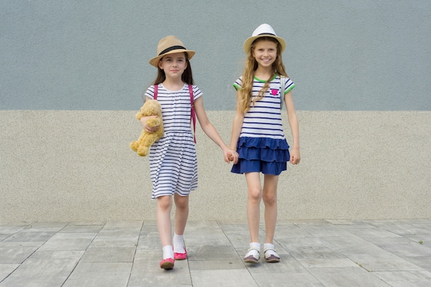 Duas namoradas bonitas de mãos dadas, meninas andando