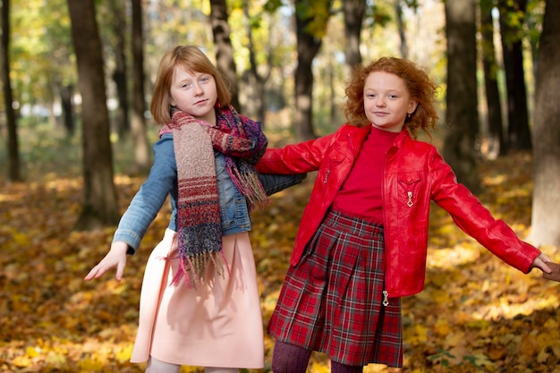 Duas namoradas correm pelo parque de outono As crianças brincam no outono