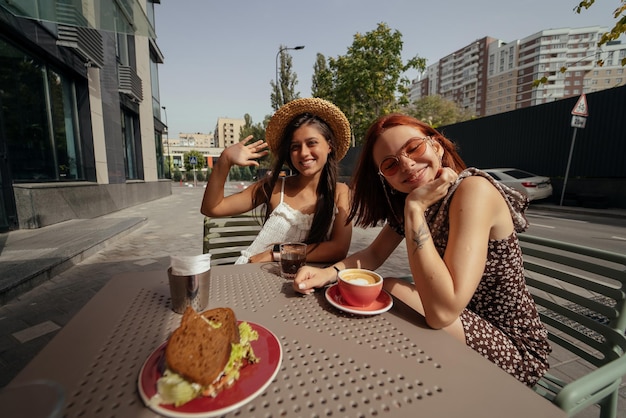 Duas namoradas de mulheres bonitas conversando em um café ao ar livre