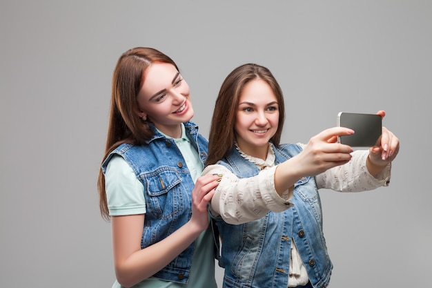 Duas namoradas em jaquetas denum fazendo selfie